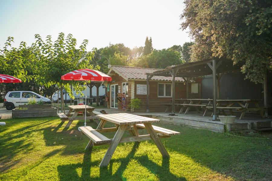 a picnic table and an umbrella in a yard at Camping Onlycamp Les Chênes Verts in Cabrières-dʼAigues