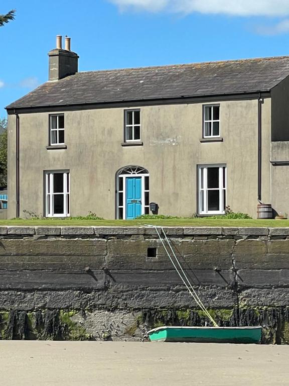 a house with a blue door and a boat in front of it at Crossing Gates House in Dundrum