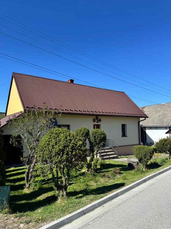 a house with a red roof on the side of the road at Domek u Krzyśka in Słopnice