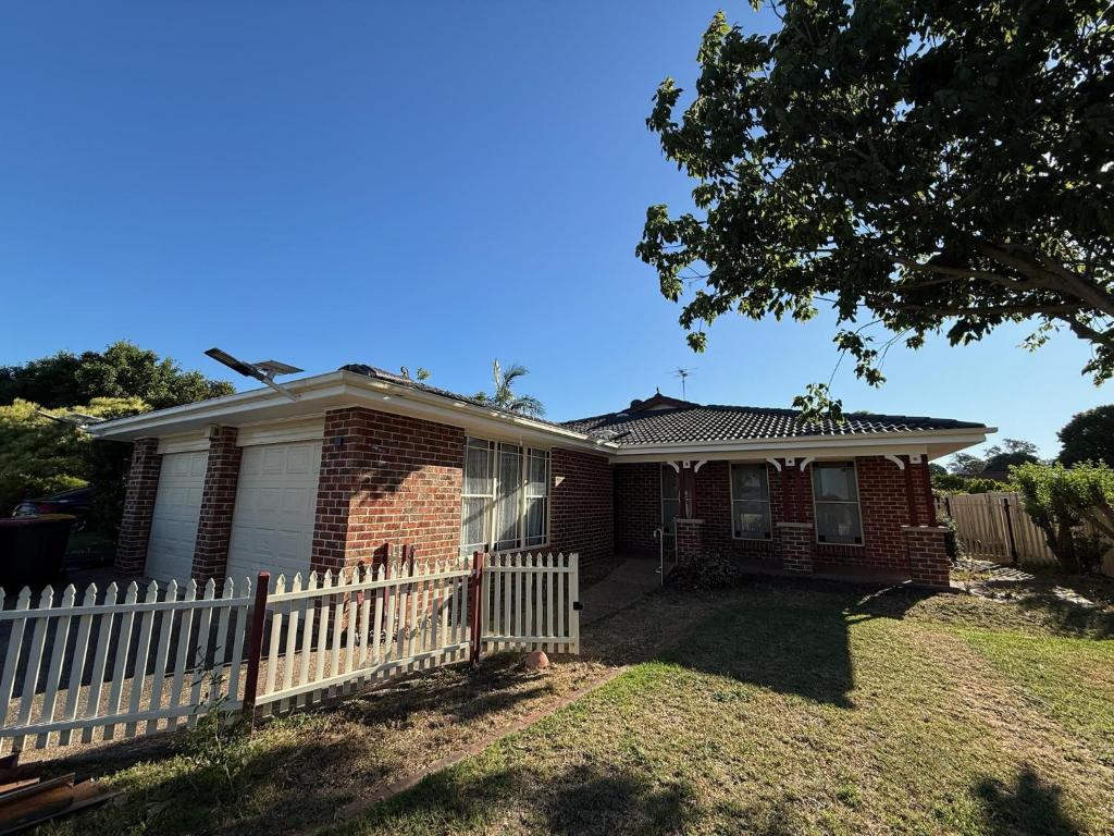 a brick house with a white picket fence at Private Rm3A in Elderslie in Elderslie