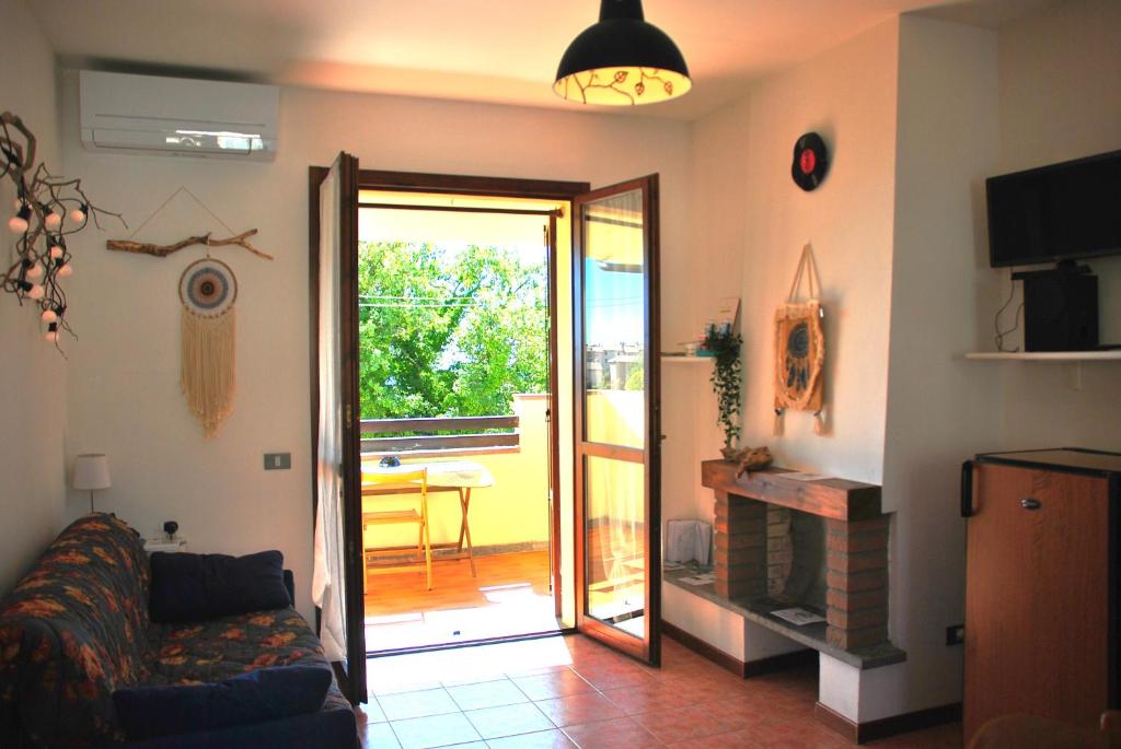 a living room with a couch and a sliding glass door at Casa Oscar in Catabbio
