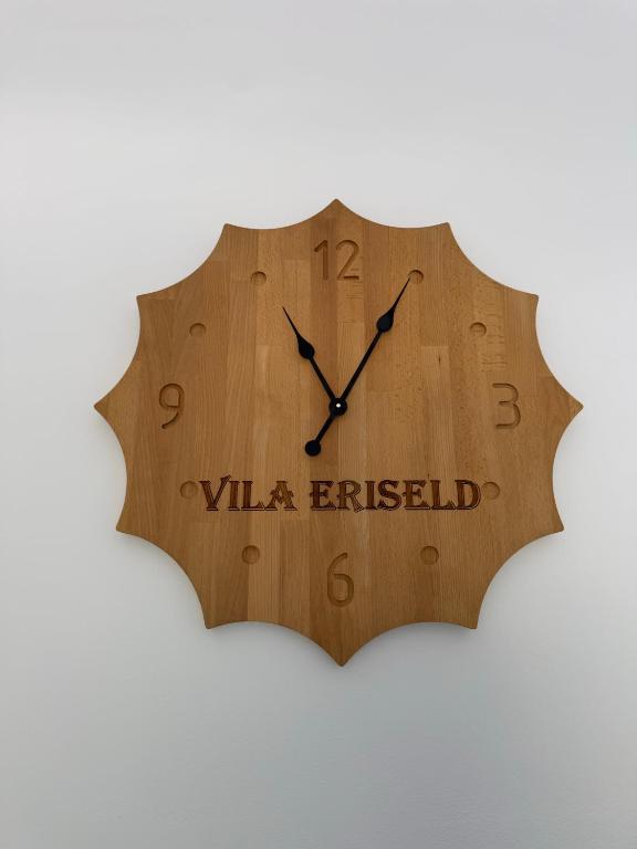 a wooden clock with the words vla erfield on it at Vila Eriseld in Ksamil