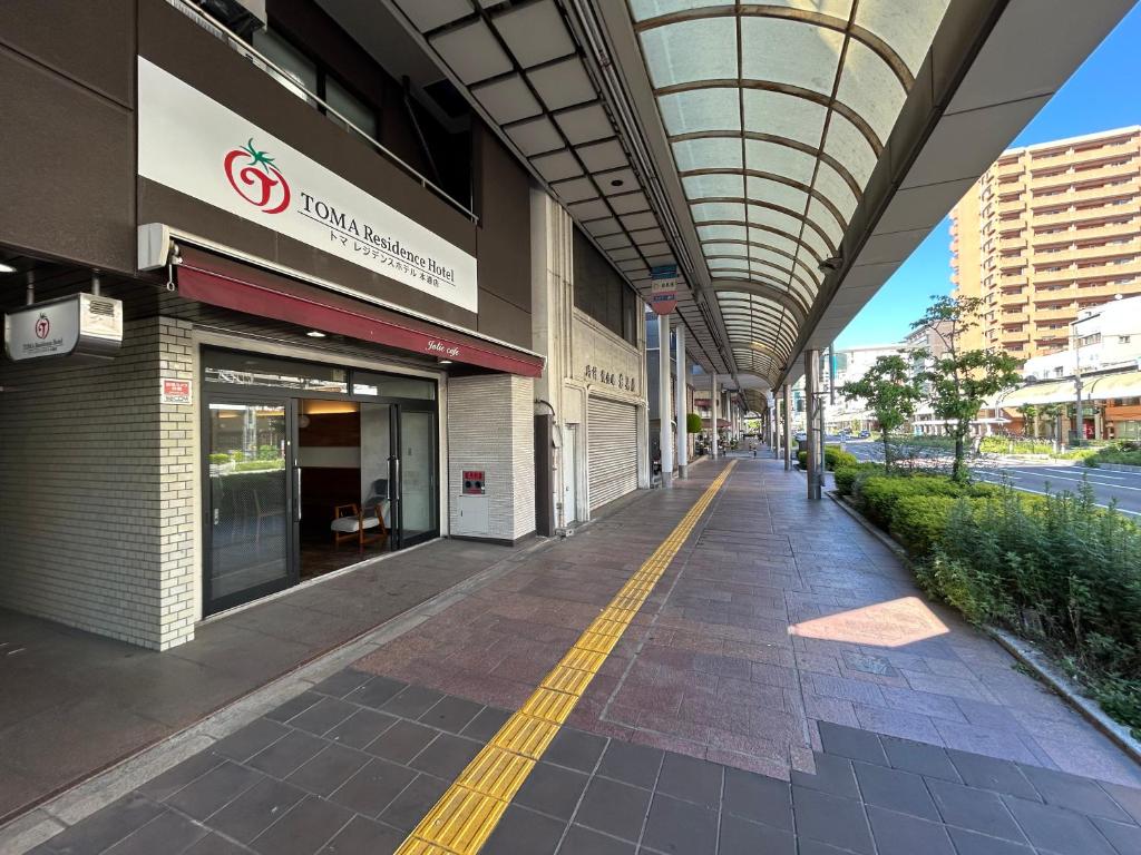 an empty sidewalk in front of a building at TOMAレジデンスホテル TOMA Residence Hotel in Kure