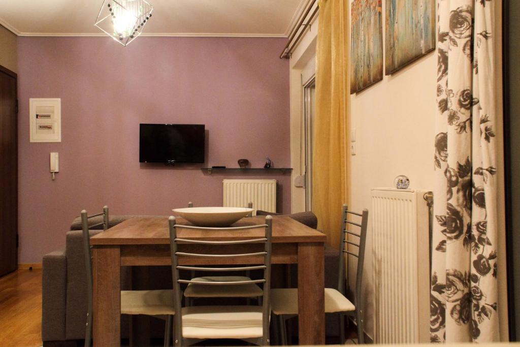 ein Esszimmer mit einem Holztisch und Stühlen in der Unterkunft Ouranos Apartment in Athen