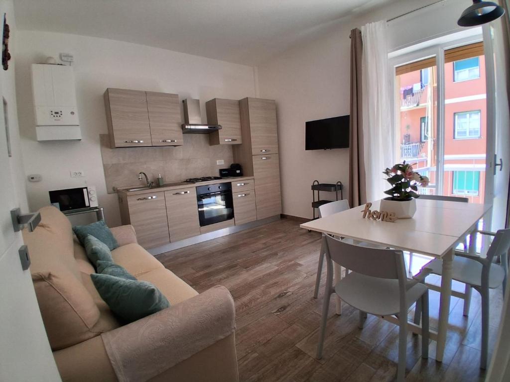 a living room and kitchen with a couch and a table at Bilocale nuovissimo! A due passi dal mare! in Levanto