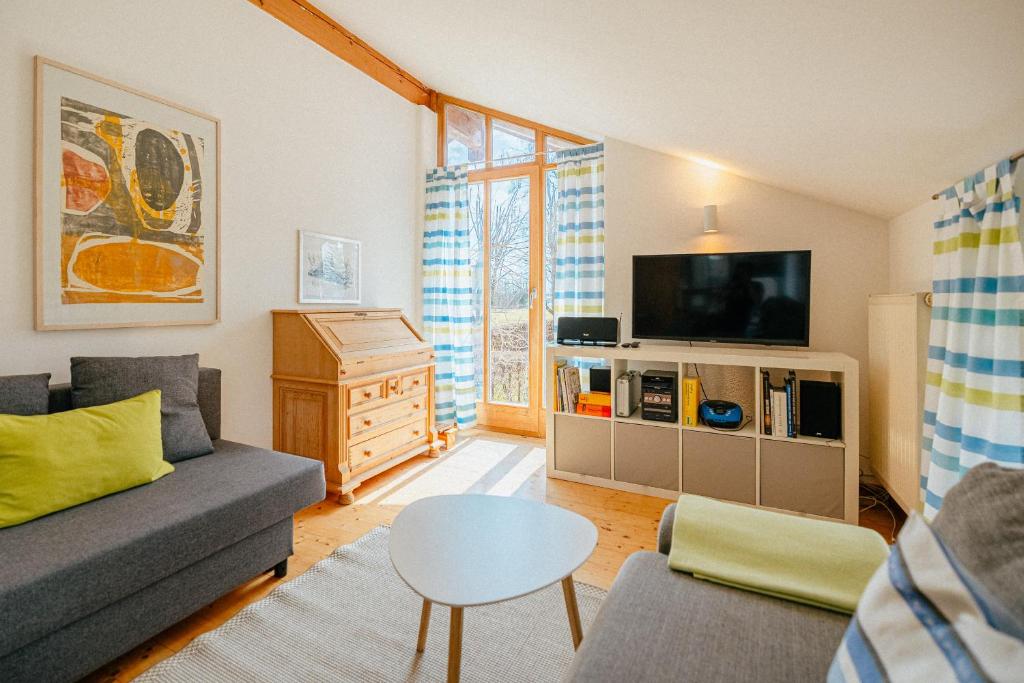 a living room with a couch and a tv at Ferienwohnung Chiemgau in Eggstätt