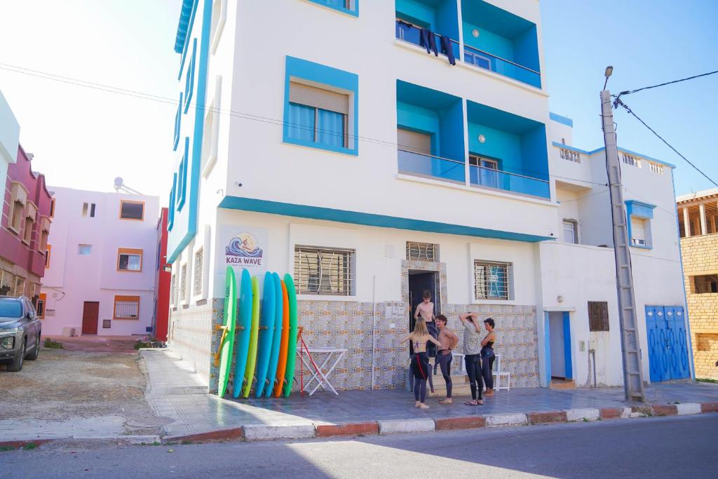 three women standing in front of a building with surfboards at KAZA Wave Surf camp in Imsouane