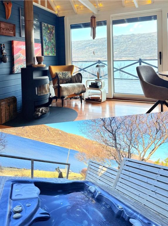 a living room with a hot tub and a fireplace at Lakefront cottage with jacuzzi in Borgarnes