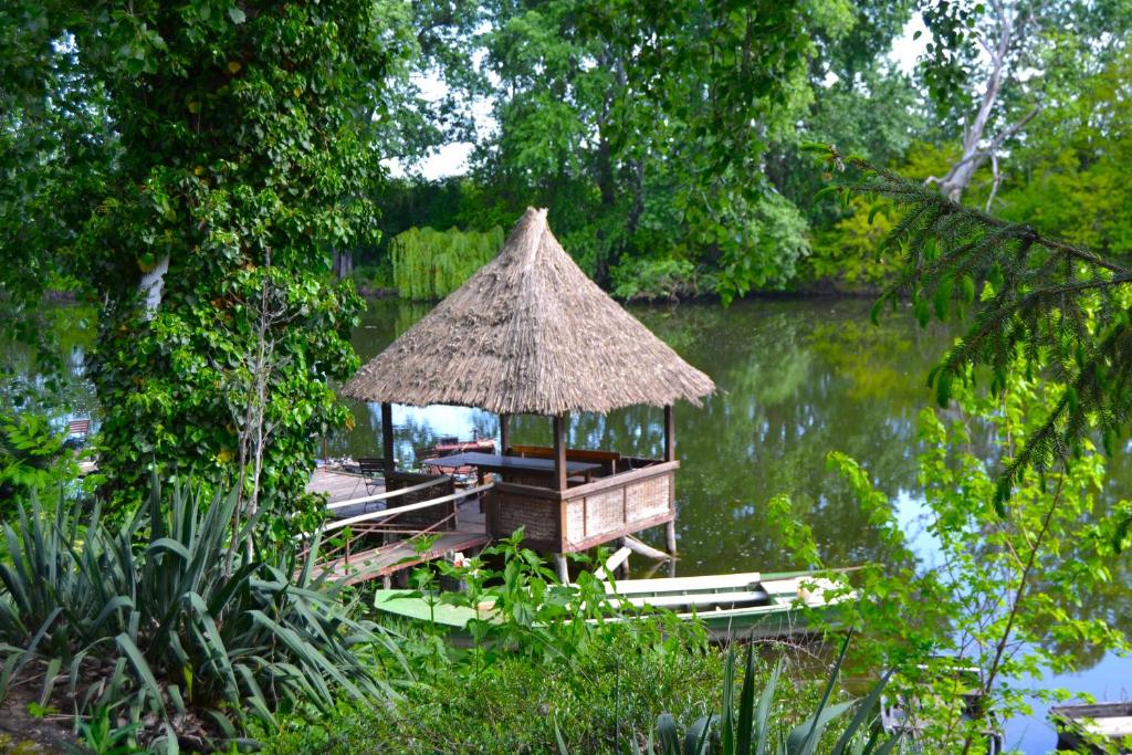 a hut on a dock in the middle of a lake at Čarda Ranč in Berava