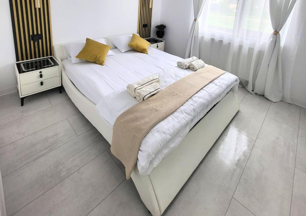 a large bed with white sheets and yellow pillows at Apartament Benicarlo2 in Brad