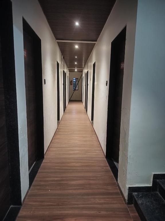 a corridor of a building with wooden floors and doors at Hotel sai laxmi residency in Lonavala
