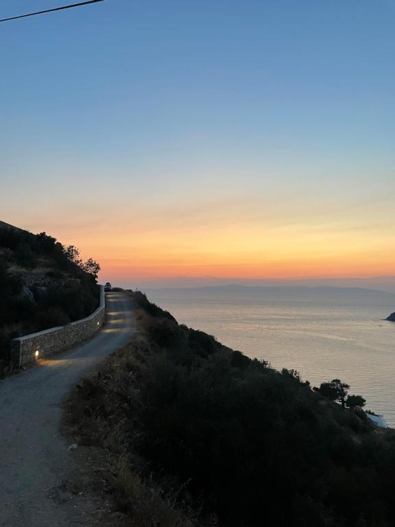 a road on the side of a hill at sunset at Cycladic House with Aegean Sea View in Aegiali