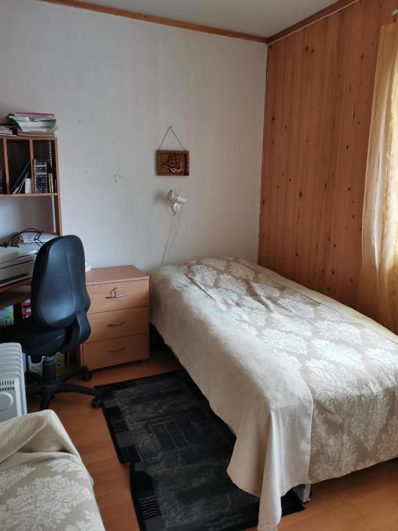 a bedroom with a bed and a desk and a chair at Room 2 in Kirkenes
