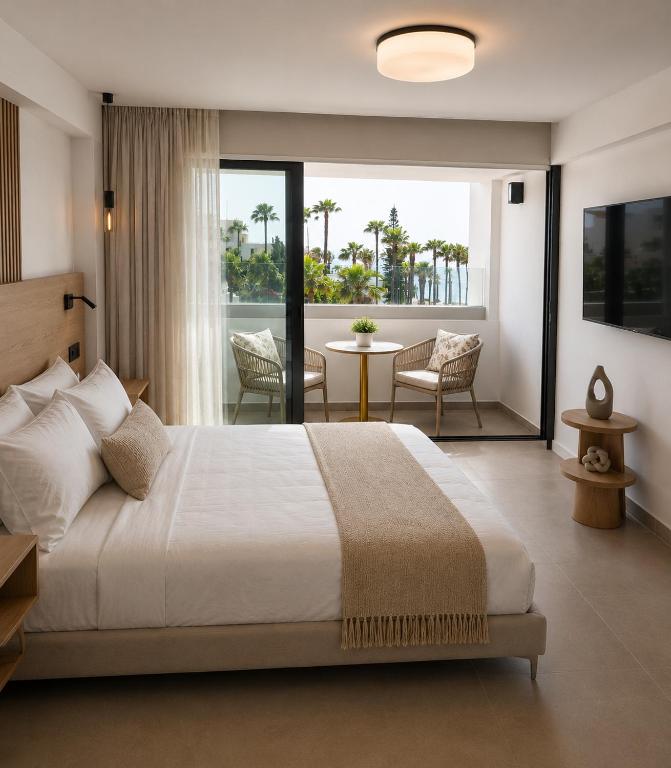 a bedroom with a large bed and a balcony at Terrazza Suites in Paphos