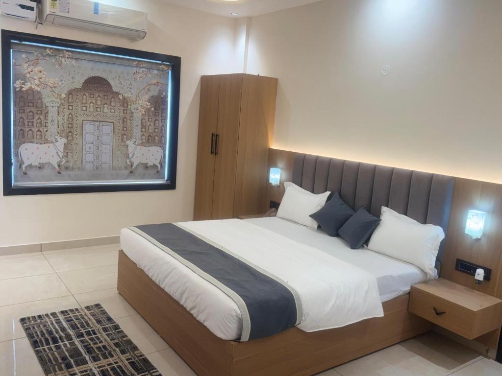 a bedroom with a large bed and a painting on the wall at Hotel Brijraj Dham in Govardhan