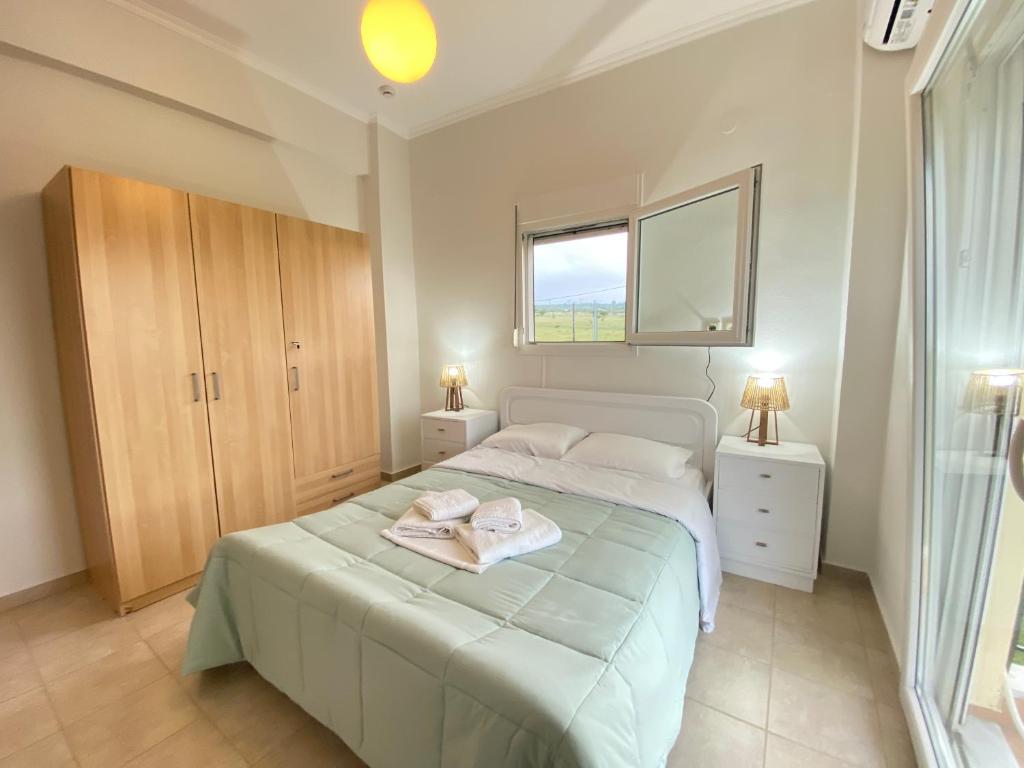 a bedroom with a large bed and a window at Olyvia in Plaka Litochorou