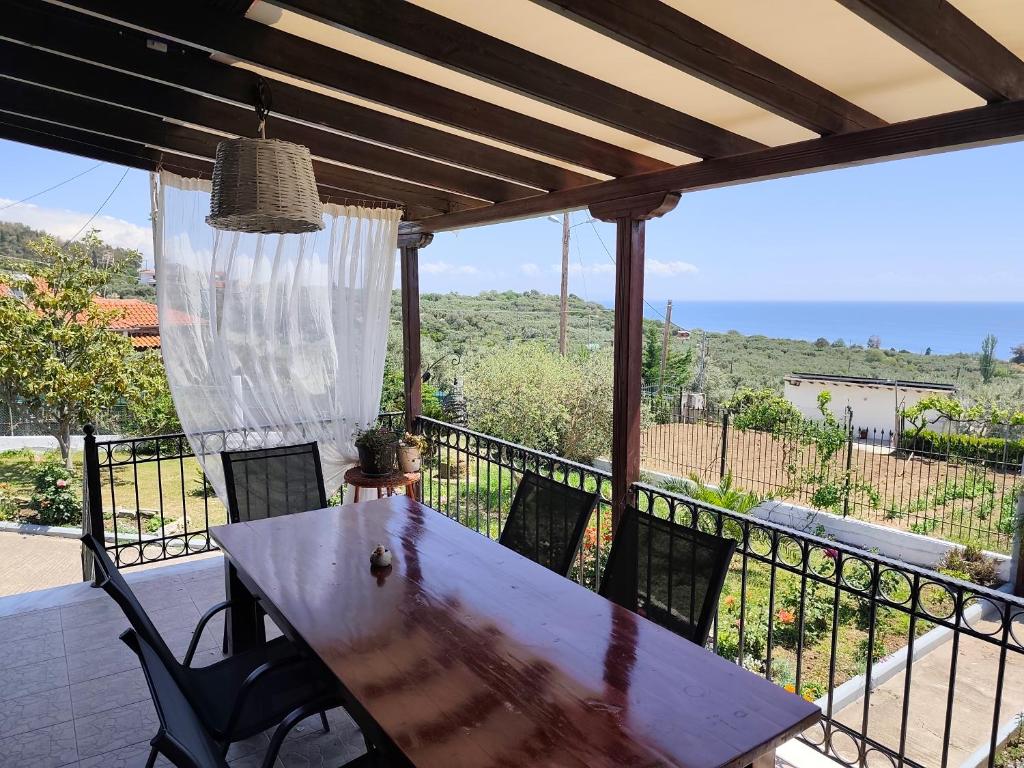 a table and chairs on a balcony with a view of the ocean at Thea Panorama in Makri