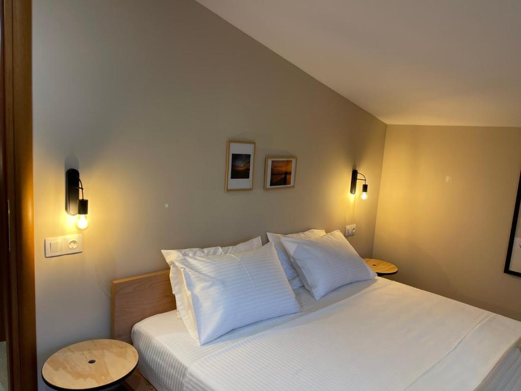 a bedroom with a bed with white sheets and pillows at theaSee Sea & Mountain View in Nea Irakleia