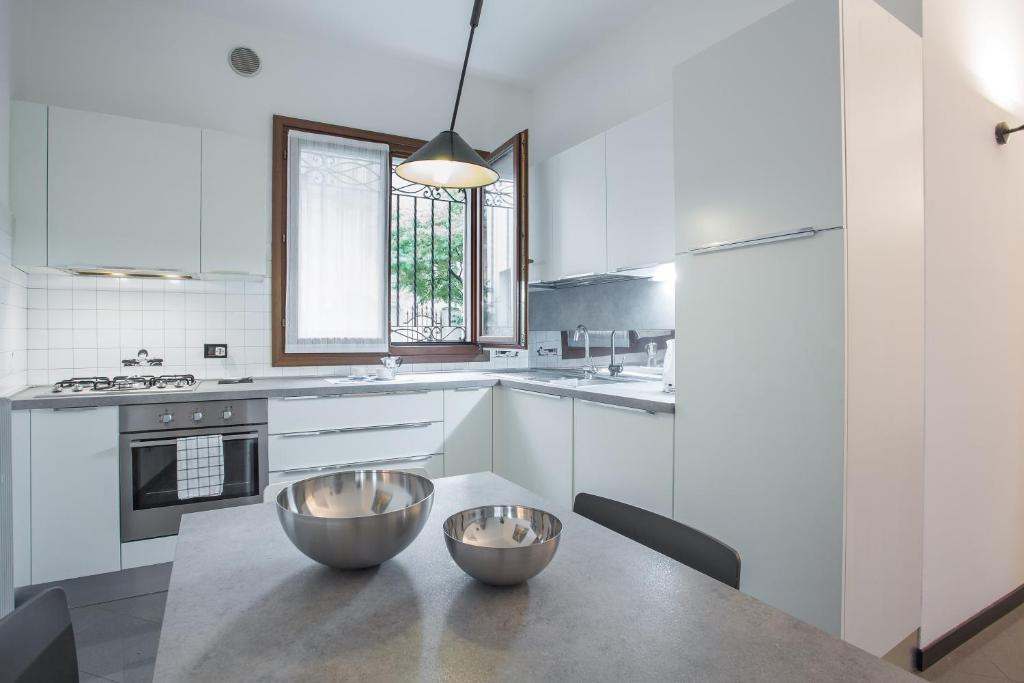 una cucina con tavolo e due ciotole sopra di Filodrammatici Loft by Welc(H)ome a Treviso