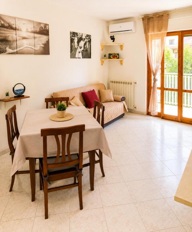 a living room with a table and a couch at MARINE KISS- Appartamento con PARCHEGGIO PRIVATO GRATUITO- Vicino Porto Crociere e Stazione in Civitavecchia
