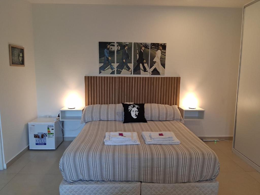 a bedroom with a bed with two towels on it at LENNON SUITE remis free Ezeiza in Ezeiza