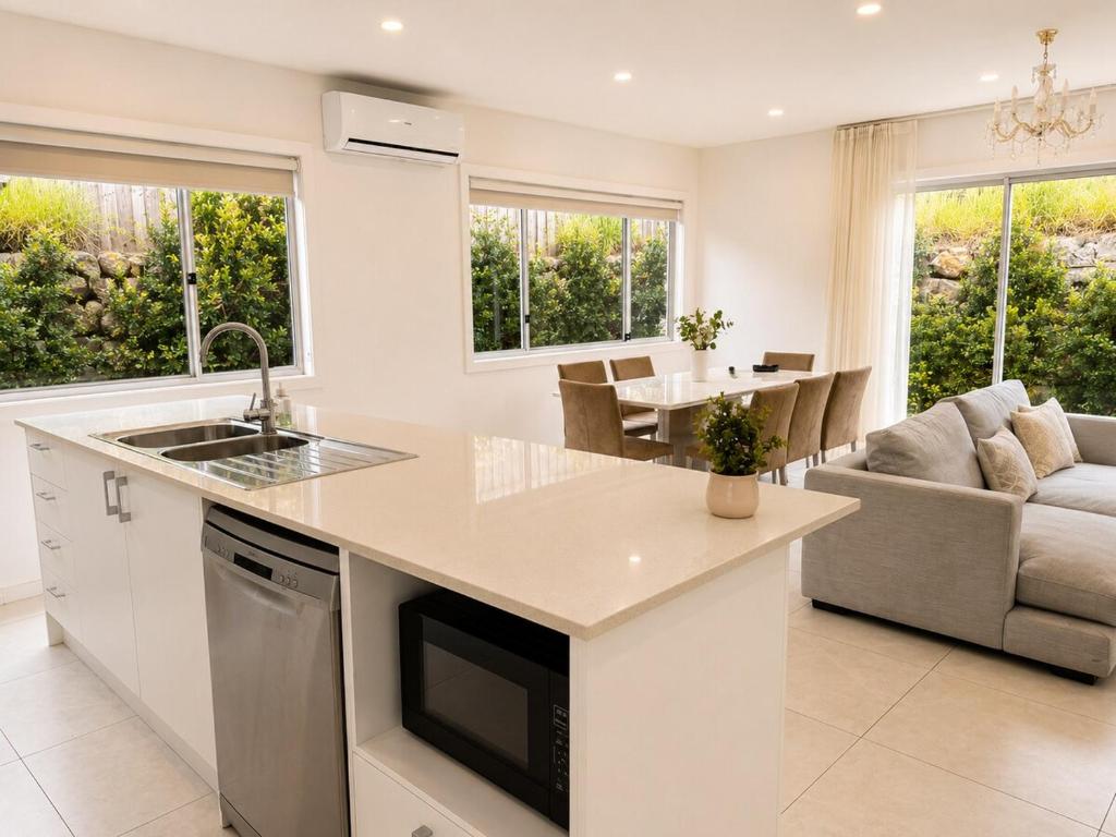 a kitchen and living room with a couch and a table at 17 Pimpama Home in Pimpama