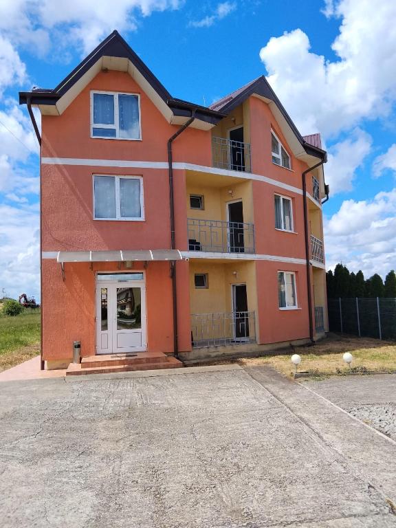 an orange house with a driveway in front of it at Hotel Doina 1 Tășnad in Tăşnad