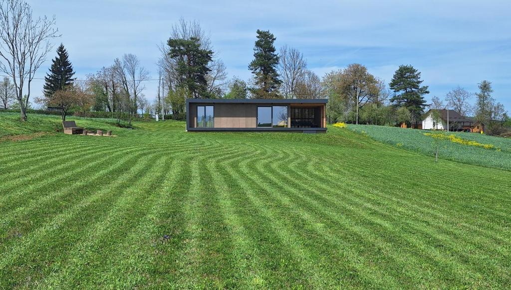 a house on a hill with a large grass field at Cube Hills in Rakovica