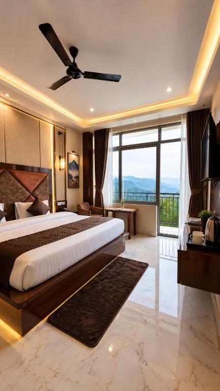 a bedroom with a large bed with a ceiling fan at Hotel Himalayan Heaven - A Most Luxury & Best Mountain View Hotel In Mussoorie By lilly in Mussoorie