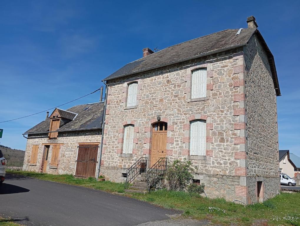 an old stone building on the side of a road at Maison de campagne in Maussac