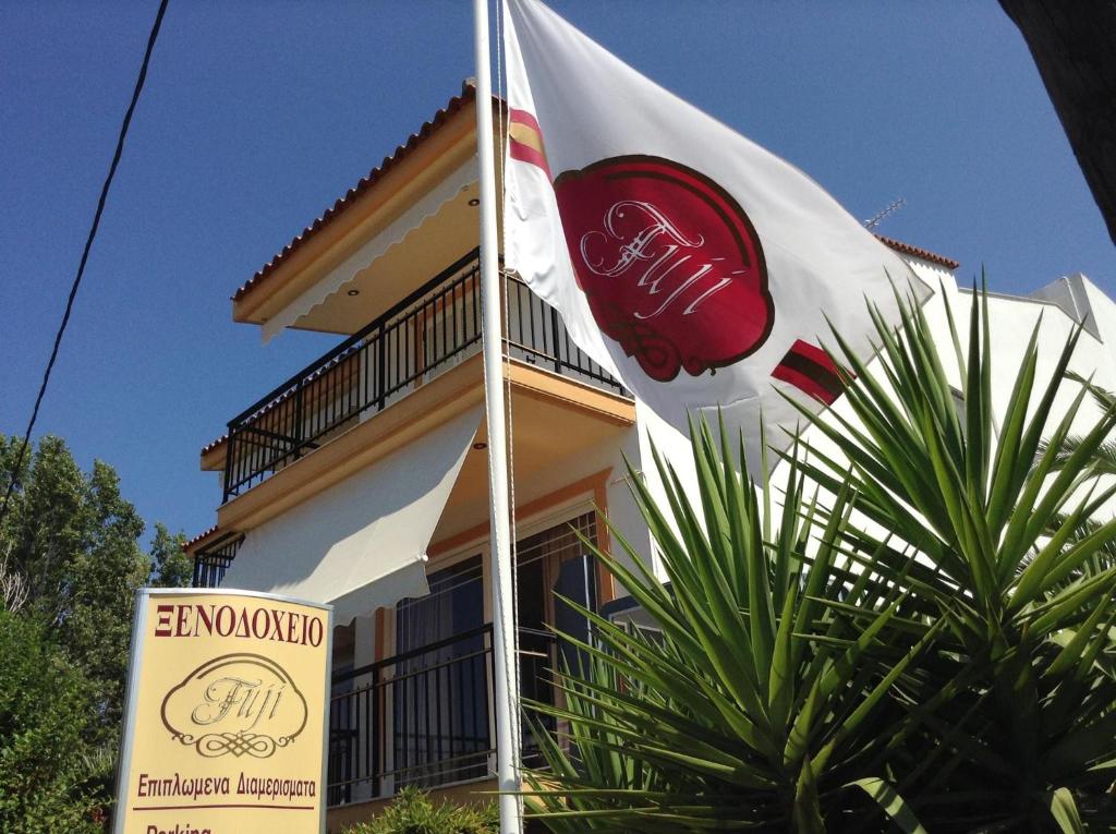 a flag flying in front of a building with a sign at Fuji Hotel in Edipsos
