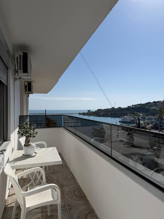 a balcony with a table and chairs and a view of the ocean at Sea You Soon Apartment in Shëngjin