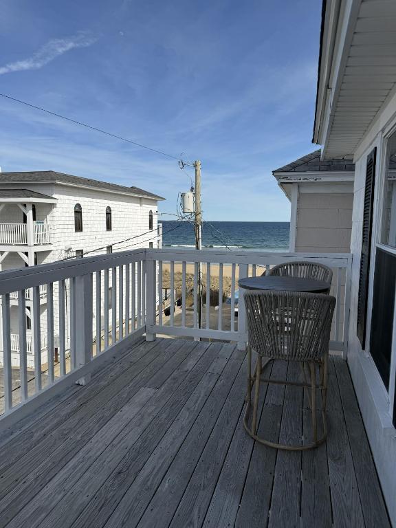a wooden deck with a table and a chair at Salty & Sweet 303 in Old Orchard Beach