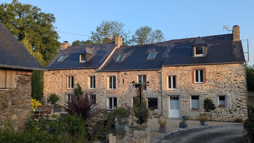 an old stone house with a courtyard at La suite de L'Eau qui dort in Pleslin-Trigavou