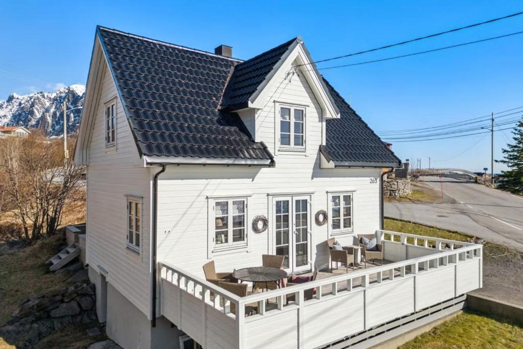 a white house with a porch with a deck at The Reine Scenic View in Moskenes