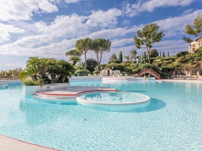 a large swimming pool with a fountain in the middle at Cap Esterel - Duplex avec 2 terrasses dont une tropezienne, piscines et loisirs in Saint-Raphaël