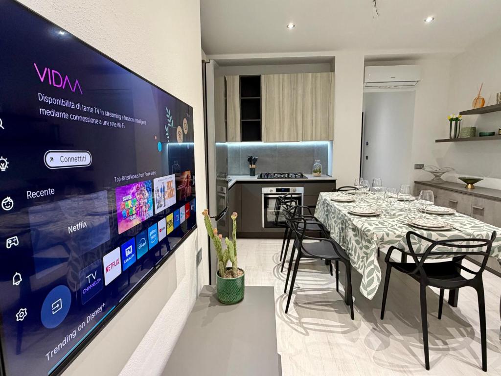 a dining room with a table and a large screen at Wake to Lake - Arona, Lago Maggiore in Arona