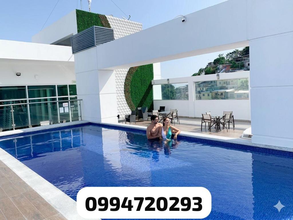 a man and a child standing in a swimming pool at Puerto Santa Ana, river view 102 in Guayaquil