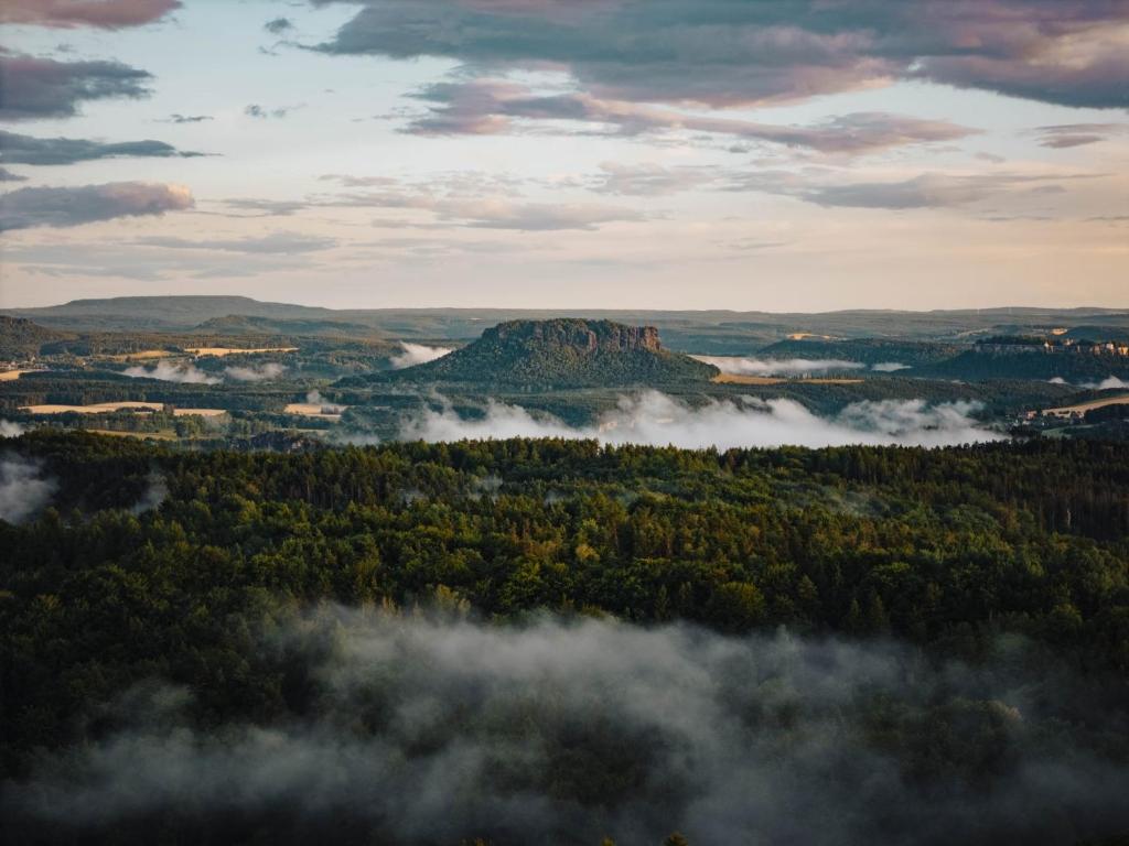 an aerial view of a valley with clouds and trees at Ferienwohnung Schwerg in Hohnstein