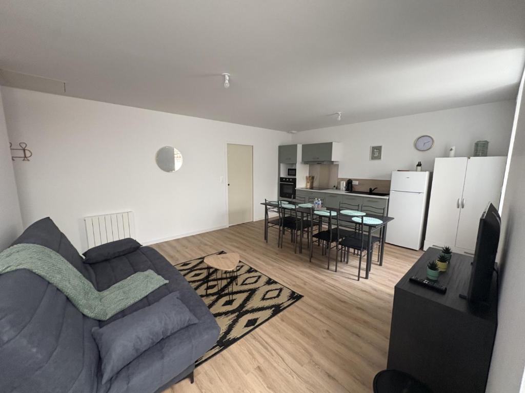 a living room with a couch and a table at LONI Expériences moderne emplacement idéal in Challans