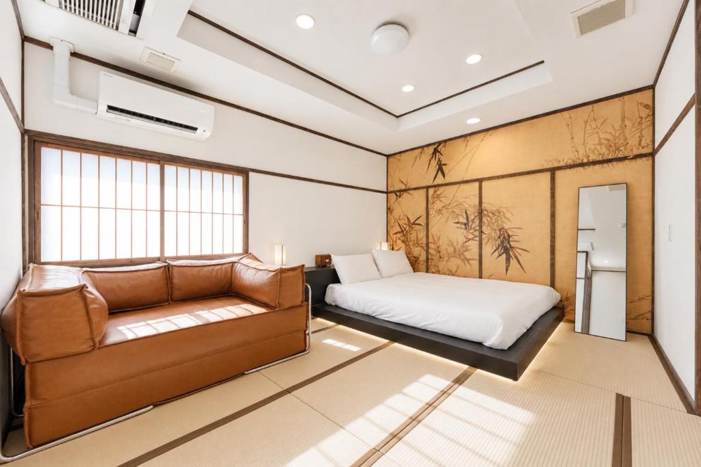 a bedroom with a bed and a couch at OYASUMI Art HOTEL Dotonbori 24-Hour Check-in Pressure-relief mattress in Osaka