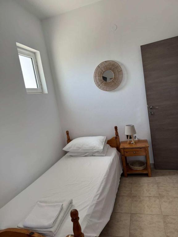 a bedroom with a bed and a mirror on the wall at Zografos 5 in Haraki