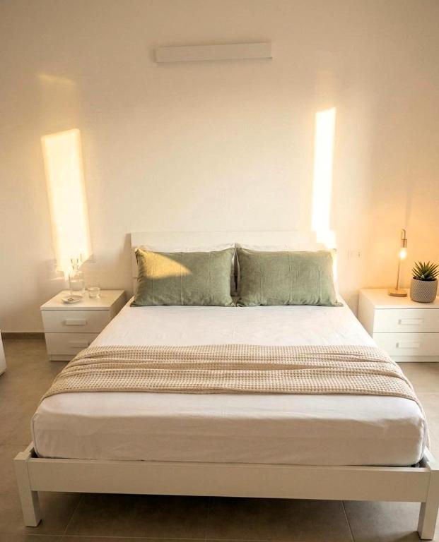 a bedroom with a large bed with two night stands at Il PuntoPiu'Alto in SantʼAntìoco