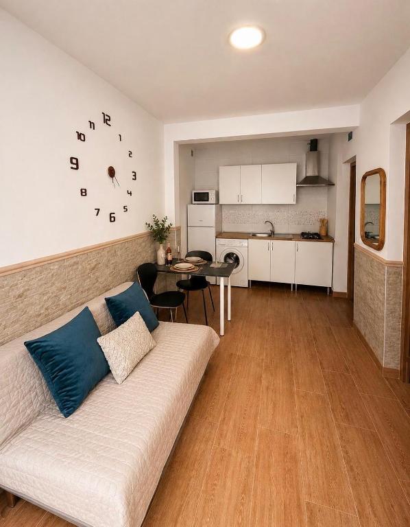 a living room with a white couch and a kitchen at Costacabana Sea Apartment in Almería