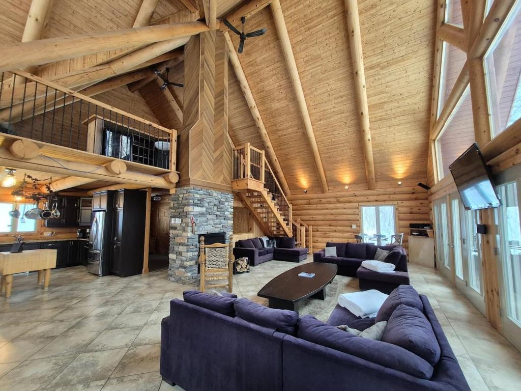a large living room with couches and a fireplace at Le Cormoran in Sainte Brigitte de Laval