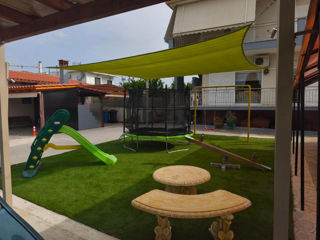 a playground with a green slide and a bench at Rea's House Vrachati in Vrachati