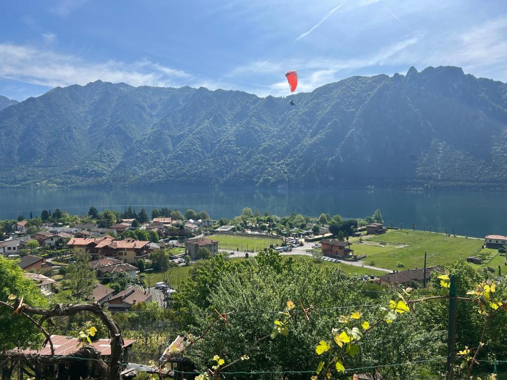 a red kite flying over a town and a lake at Lake Retreat in Anfo