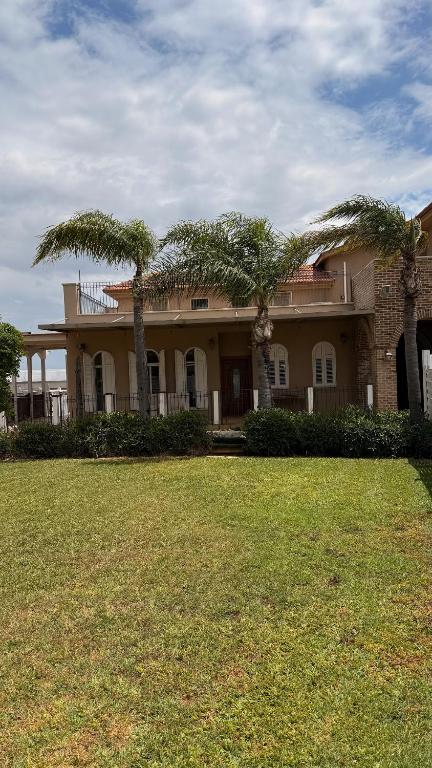 a large house with palm trees in front of it at נורית בעמק in Gan Yoshiyya