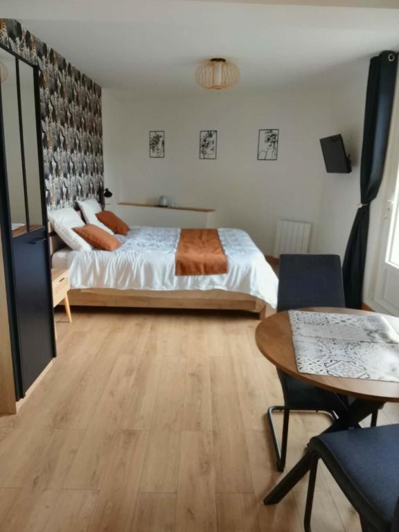 a bedroom with a bed and a table in a room at Ma Bulle Confort in Pouzauges