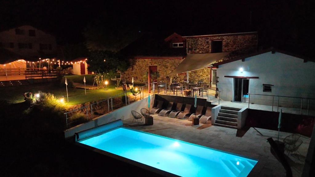 a swimming pool in a backyard at night at Bed & Breakfast Perbos 1556 in Labastide-Clairence